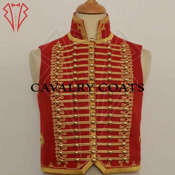 A Cavalry Officer Hussar Waistcoat is displayed. It features a rich, deep blue fabric with intricate gold braiding and embroidery on the front. The waistcoat has a high collar and multiple rows of horizontal gold braid across the chest, typical of Hussar military uniforms. The edges are trimmed with gold piping, and there are ornate buttons in a double-breasted arrangement. The overall design reflects the opulence and detailed craftsmanship of military attire from the Hussar regiments.